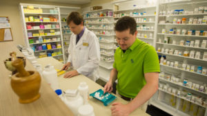 pharmacists behind counter filling perscription medication