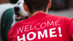 Student facing away from camera in t-shirt that reads Welcome Home