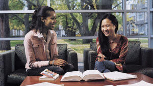 students at library table with books