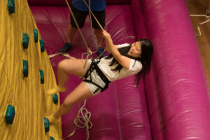 A student climbs an inflatable rock wall during Sup All Night.